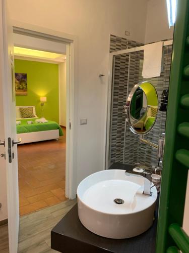 Villa Zufrò في فيبو فالينتيا: حمام مع حوض أبيض وغرفة نوم