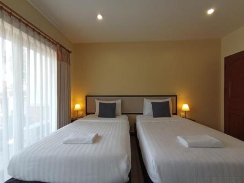 two beds in a hotel room with two beds sidx sidx sidx at Pak Ping Rim Khong in Chiang Saen