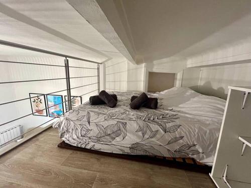 une chambre avec un grand lit avec des oreillers dessus dans l'établissement Charmant studio mezzanine au cœur de Nice, à Nice