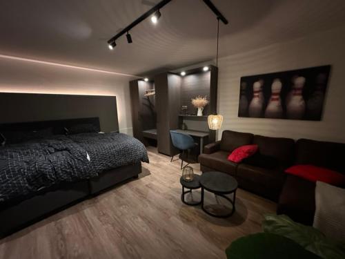 ein Schlafzimmer mit einem Bett und einem Sofa in der Unterkunft Apartment Hideaway in Bad Oeynhausen