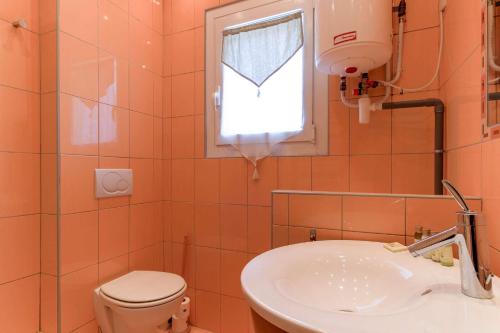 La salle de bains est pourvue d'un lavabo, de toilettes et d'une fenêtre. dans l'établissement SELECT'soHOME - Studio pour 2 personnes sur la plage du Lavandou avec parking privé ! - FREGATE-04, au Lavandou