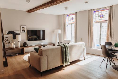 a living room with a couch and a tv at The Guest Apartments in Den Bosch