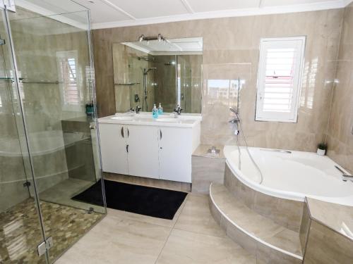 a bathroom with a tub and a sink and a shower at Villa on Maxi in Velddrif