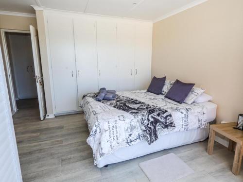 a bedroom with a bed with a black and white comforter at Villa on Maxi in Velddrif