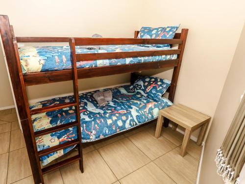 a bedroom with two bunk beds and a stool at Villa on Maxi in Velddrif