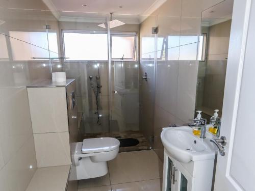 a bathroom with a shower and a toilet and a sink at Villa on Maxi in Velddrif
