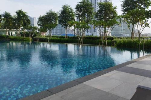 uma grande piscina de água azul com árvores e edifícios em Affordable Residence Plaza @ KJ em Petaling Jaya