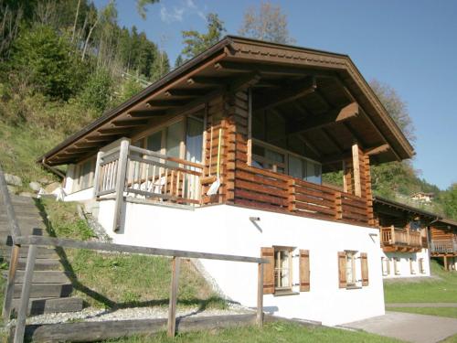 een blokhut met een veranda en een balkon bij Luxurious chalet with sauna in K nigsleiten in Wald im Pinzgau