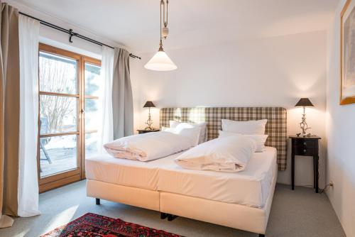 - une chambre avec un lit doté de draps blancs et une fenêtre dans l'établissement Ferienwohnung Suite-Mathilda, à Reit im Winkl