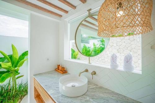 ein Bad mit einem Waschbecken und einem Spiegel in der Unterkunft The Putih Tiny Villa - Stylish Mezzanine Loft 5mins to Nyanyi Beach in Tanah Lot