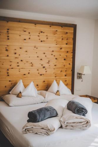 a white bed with two pillows on top of it at Hotel Enzian - Adults Only in Obertauern