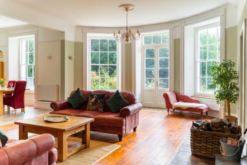 a living room with a couch and a table at Holyland House - Greenacres Estates in Pembrokeshire