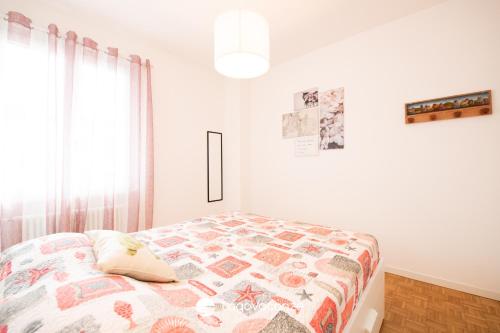 a bedroom with a bed with a quilt on it at Sweet Home Padenghe in Padenghe sul Garda