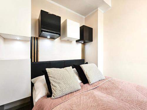 a bedroom with a bed with a tv on the wall at visit baltic - Kwartał Róży Wiatrów apartament SK30 z parkingiem in Świnoujście