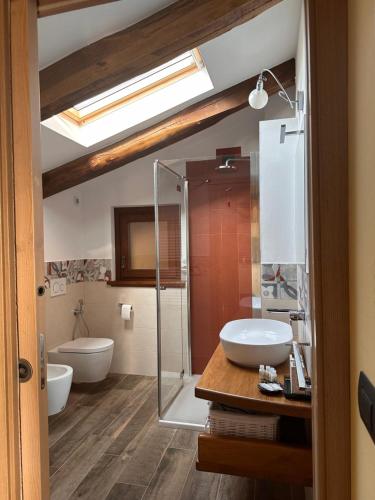 La salle de bains est pourvue d'un lavabo et d'une douche en verre. dans l'établissement Cascina Coste, à Roppolo