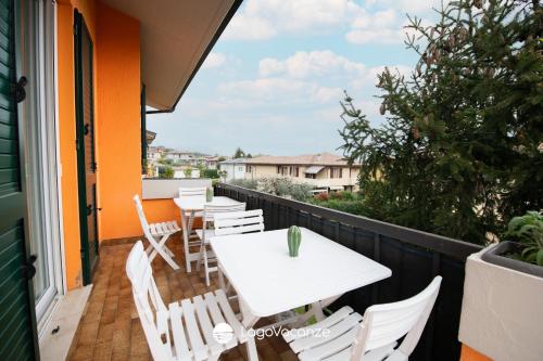 a balcony with a white table and chairs at Sweet Home Padenghe in Padenghe sul Garda