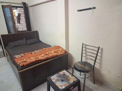 a bedroom with a bed and a chair in it at Gorakhnath Guest House in Gorakhpur