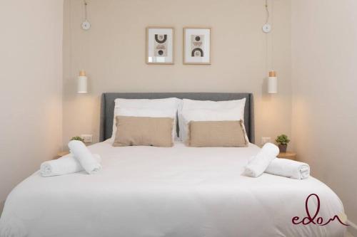 um quarto com uma grande cama branca com almofadas em דירת 2 חדרי שינה עם נוף מדהים לים - By Edom em Eilat