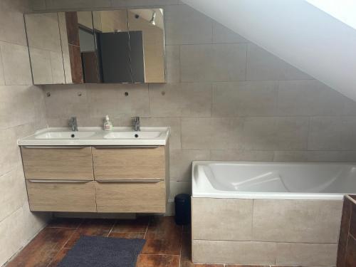 een badkamer met een wastafel en een bad bij Maison familiale avec vue dégagée in Vaux-lès-Prés