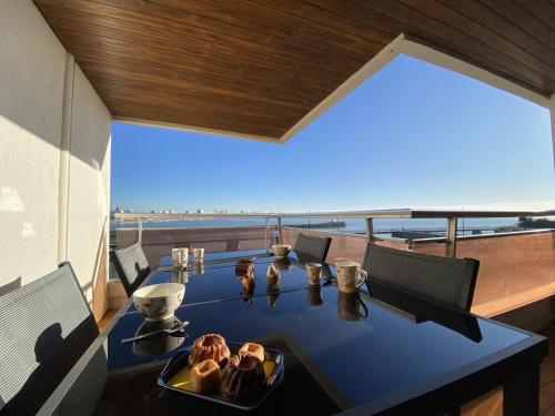 - une table avec une assiette de nourriture sur le balcon dans l'établissement Studio face mer a la Chaume, à Les Sables-dʼOlonne