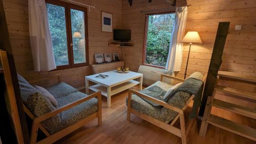 ビロンにあるChalets de vacances Castelwoodの椅子とテーブルが備わる客室です。