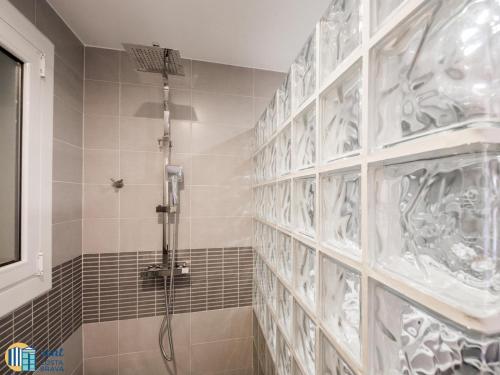 a bathroom with a shower with a tile wall at Villa colette in Sant Antoni de Calonge