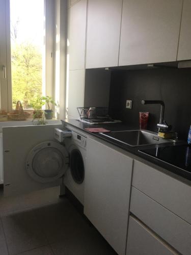 a kitchen with a washing machine and a sink at Perfect spacious Vacation center of city in Berlin