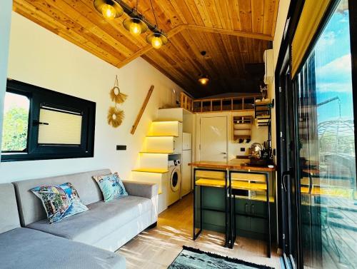a living room with a couch and a kitchen at Yucca tiny house in Orta