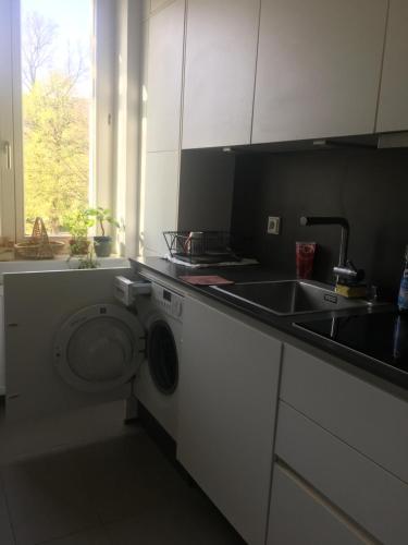 a kitchen with a washing machine and a sink at Perfect spacious Vacation center of city in Berlin