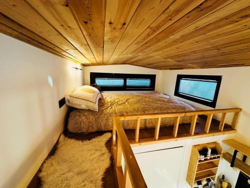 a bed in a small room with a wooden ceiling at Yucca tiny house in Orta