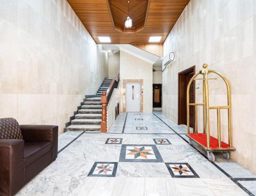 eine Lobby mit einer Treppe, einem Sofa und Fliesenboden in der Unterkunft درب البحر in Dschidda