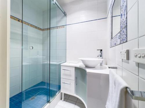 a bathroom with a sink and a glass shower at Elegant Bayside Retreat with Stunning Bay Views in Melbourne