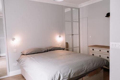 um quarto branco com uma cama e uma cómoda em Sapphire Sanctuary em Londres