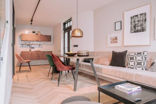 uma sala de estar com um sofá e uma mesa em The Guest Apartments - Lange Putstraat em Den Bosch