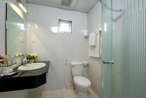 a bathroom with a toilet and a sink and a shower at Palago Park View Hotel in Ho Chi Minh City