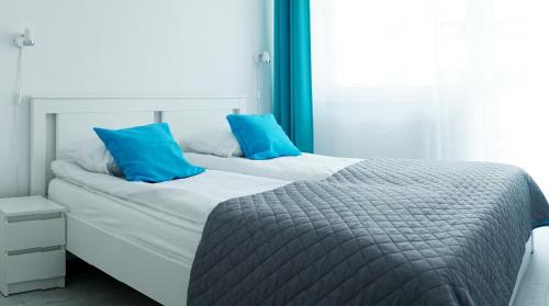 a bedroom with two beds with blue pillows at Bliżej Morza Apartament 57 in Kołobrzeg