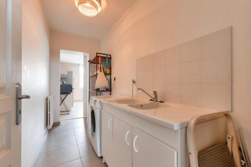 une cuisine avec un évier et une machine à laver dans l'établissement Maison 4 chambres aux Sables d'Olonne, à Les Sables-dʼOlonne