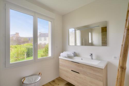 ein Bad mit einem Waschbecken und einem Fenster in der Unterkunft Détente et découverte du Pays Bigouden in Plonéour-Lanvern
