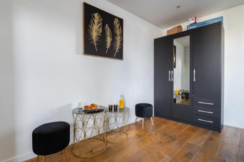 a living room with a black door and two chairs at Studio cosy metro saint Paul - Paris 3 - 2P in Paris