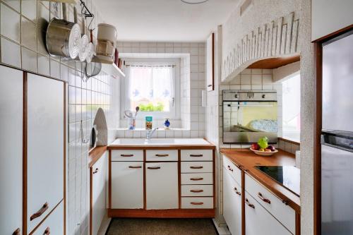 a kitchen with white cabinets and a sink at Vacances en famille à Ile-Tudy in Île-Tudy