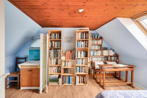 Zimmer mit Bücherregalen und einem Schreibtisch im Dachgeschoss in der Unterkunft Vacances en famille à Ile-Tudy in Île-Tudy