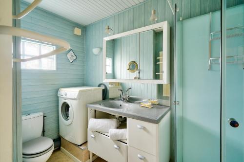 ein Badezimmer mit einem Waschbecken und einer Waschmaschine in der Unterkunft Vacances en famille à Ile-Tudy in Île-Tudy