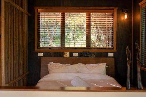 a bedroom with a bed with a large window at Modern, Cosy Hideaway - Rua Nuka Raglan in Raglan