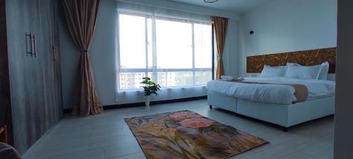 a bedroom with a bed and a large window at The Hills View in Nairobi