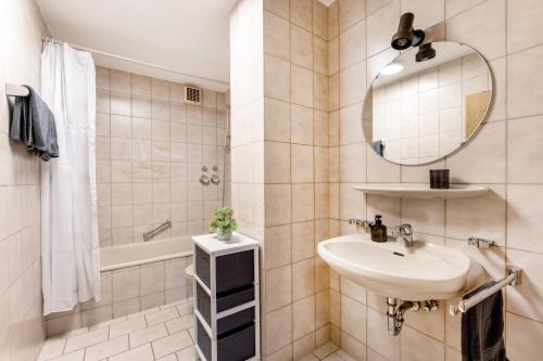ein Badezimmer mit einem Waschbecken, einem Spiegel und einer Badewanne in der Unterkunft Juri/35 Schwenningen in Villingen-Schwenningen