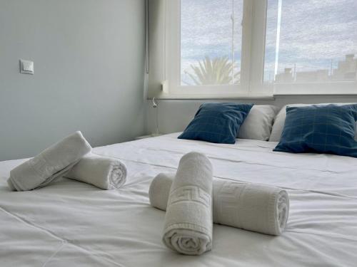 a white bed with towels on it with a window at Apartamento La Caleta III - Monabri in Mogro