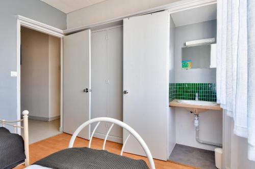 une petite chambre avec un lit et un lavabo dans l'établissement Séjour au coeur de l'Île-de-Noirmoutier, à Noirmoutier-en-l'lle