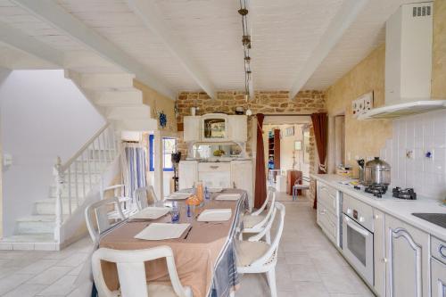 - une cuisine avec une grande table et des chaises dans l'établissement Maison avec terasse et jardin - 1km plage de Kérity, à Penmarcʼh