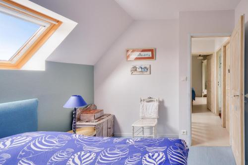 a bedroom with a blue bed and a window at Maison avec terasse et jardin - 1km plage de Kérity in Kérity