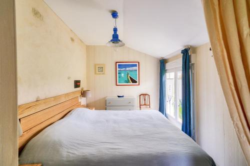 a bedroom with a large bed and a window at Maison avec terasse et jardin - 1km plage de Kérity in Kérity